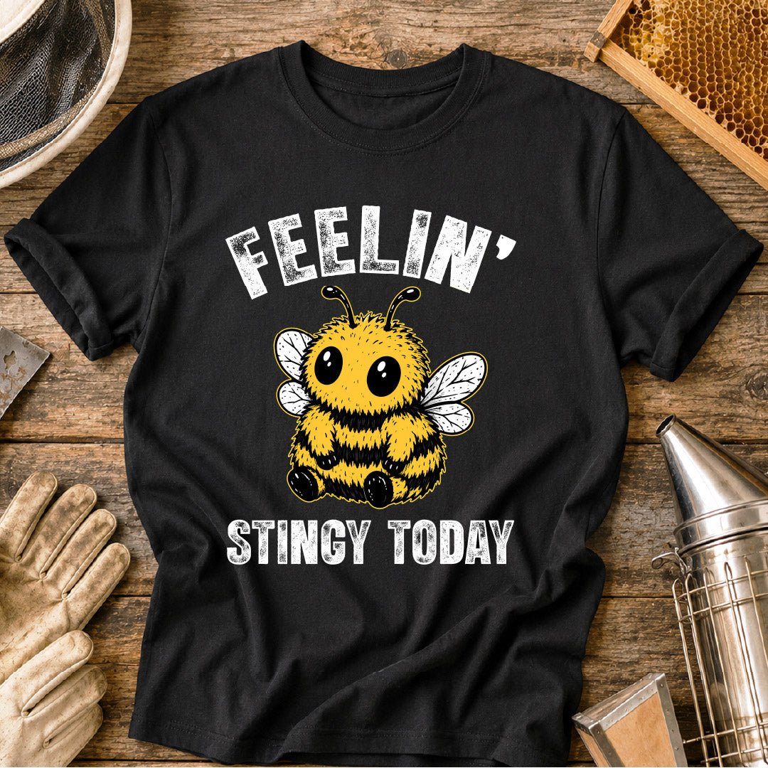 Cute bee shirt design featuring a fluffy cartoon honey bee with big eyes and the phrase “Feelin’ Stingy Today,” a funny bee pun graphic for beekeepers and bee lovers.