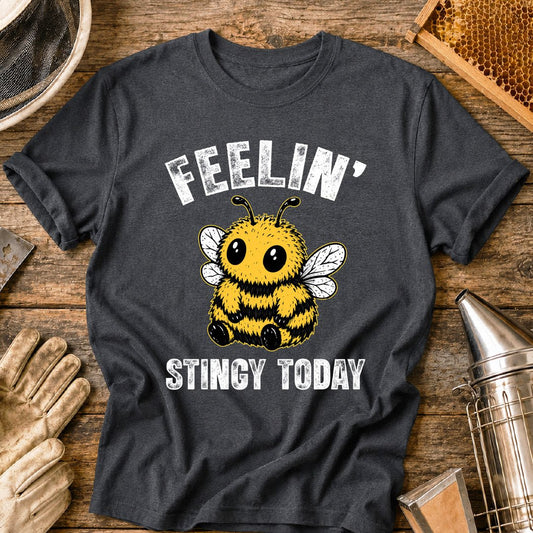 Cute bee shirt design featuring a fluffy cartoon honey bee with big eyes and the phrase “Feelin’ Stingy Today,” a funny bee pun graphic for beekeepers and bee lovers.