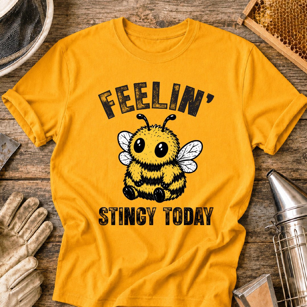 Cute bee shirt design featuring a fluffy cartoon honey bee with big eyes and the phrase “Feelin’ Stingy Today,” a funny bee pun graphic for beekeepers and bee lovers.