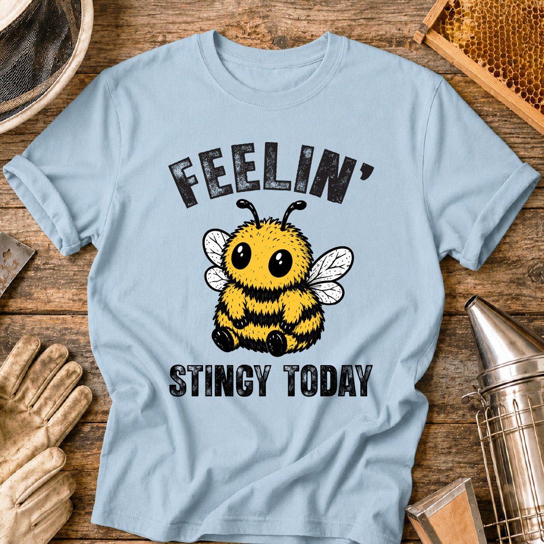 Cute bee shirt design featuring a fluffy cartoon honey bee with big eyes and the phrase “Feelin’ Stingy Today,” a funny bee pun graphic for beekeepers and bee lovers.