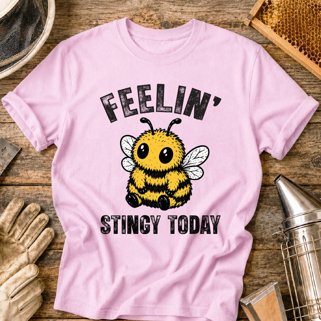 Cute bee shirt design featuring a fluffy cartoon honey bee with big eyes and the phrase “Feelin’ Stingy Today,” a funny bee pun graphic for beekeepers and bee lovers.
