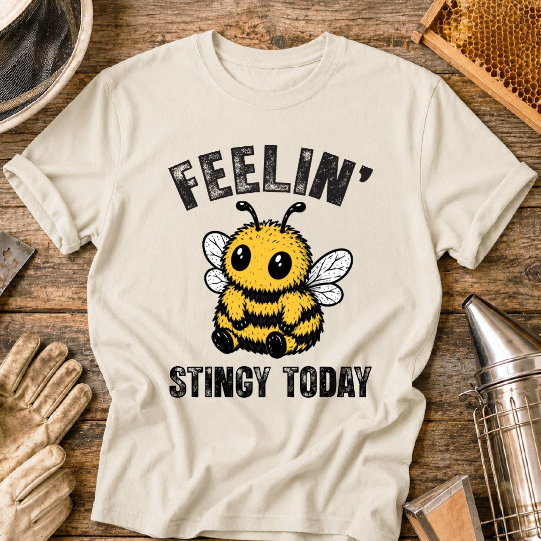 Cute bee shirt design featuring a fluffy cartoon honey bee with big eyes and the phrase “Feelin’ Stingy Today,” a funny bee pun graphic for beekeepers and bee lovers.