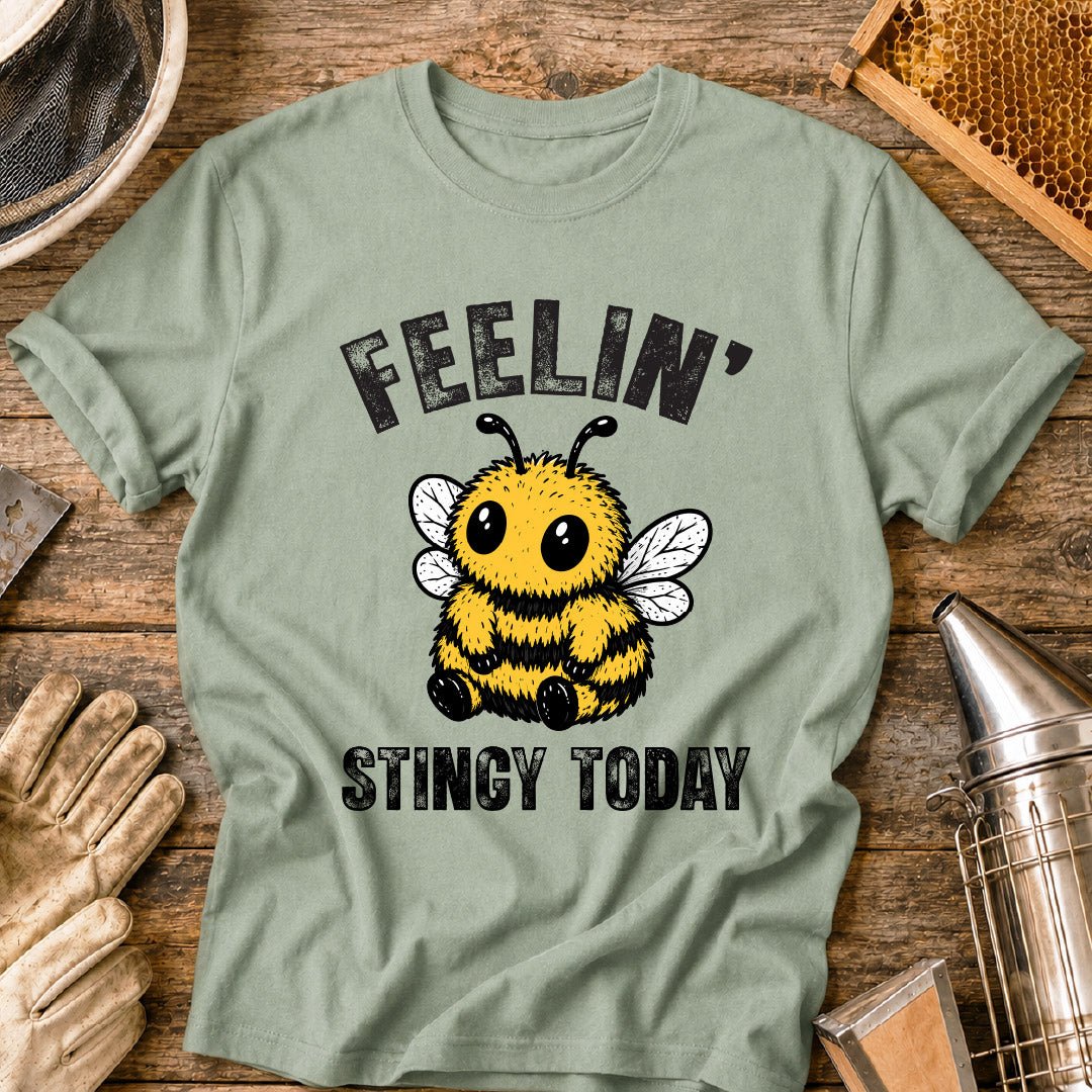 Cute bee shirt design featuring a fluffy cartoon honey bee with big eyes and the phrase “Feelin’ Stingy Today,” a funny bee pun graphic for beekeepers and bee lovers.