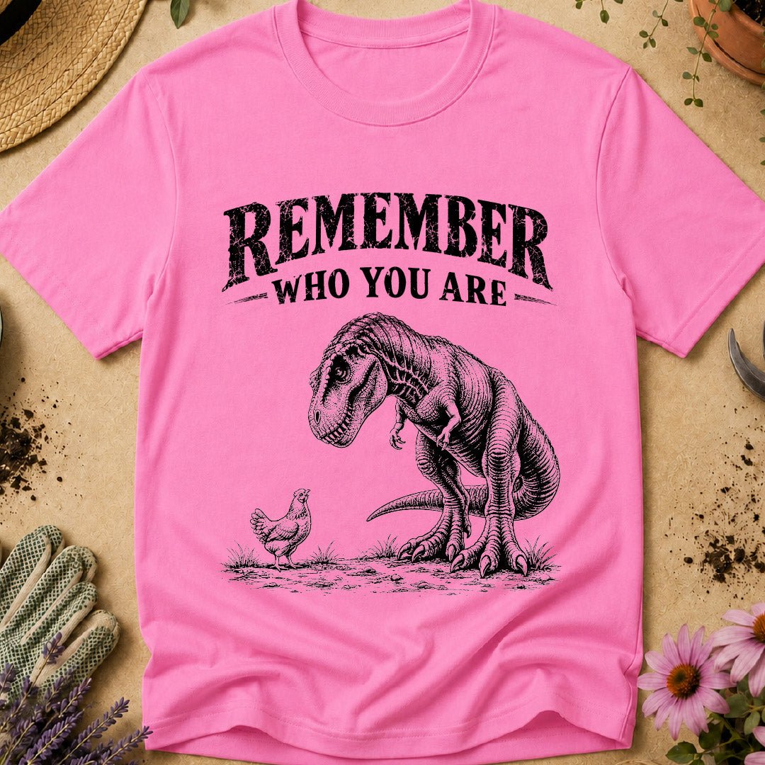 Funny chicken keeper shirt featuring a T. rex looking down at a chicken with “Remember Who You Are,” a humorous dinosaur chicken T-shirt for backyard chicken keepers and chicken lovers.