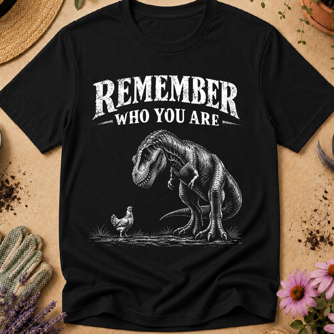 Funny chicken keeper shirt featuring a T. rex looking down at a chicken with “Remember Who You Are,” a humorous dinosaur chicken T-shirt for backyard chicken keepers and chicken lovers.