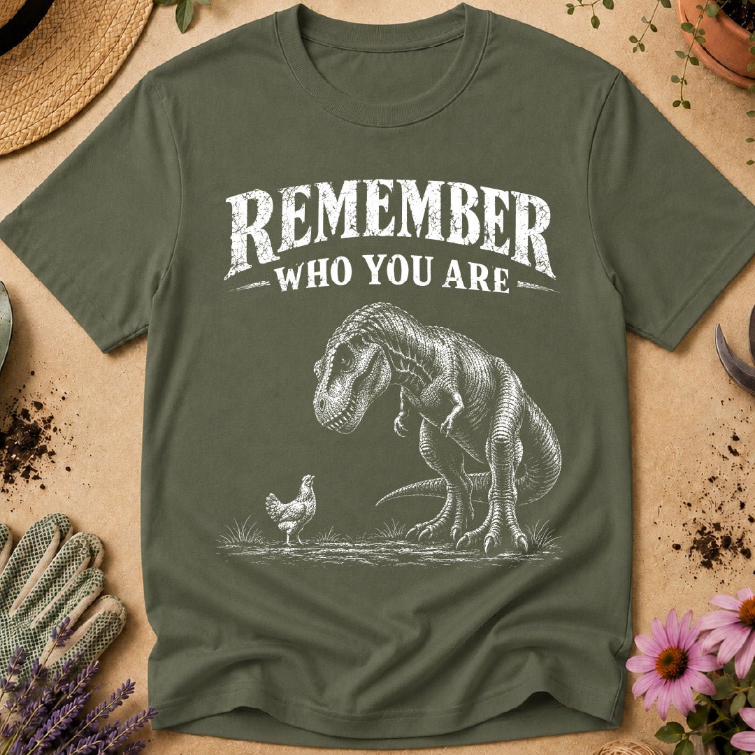 Funny chicken keeper shirt featuring a T. rex looking down at a chicken with “Remember Who You Are,” a humorous dinosaur chicken T-shirt for backyard chicken keepers and chicken lovers.
