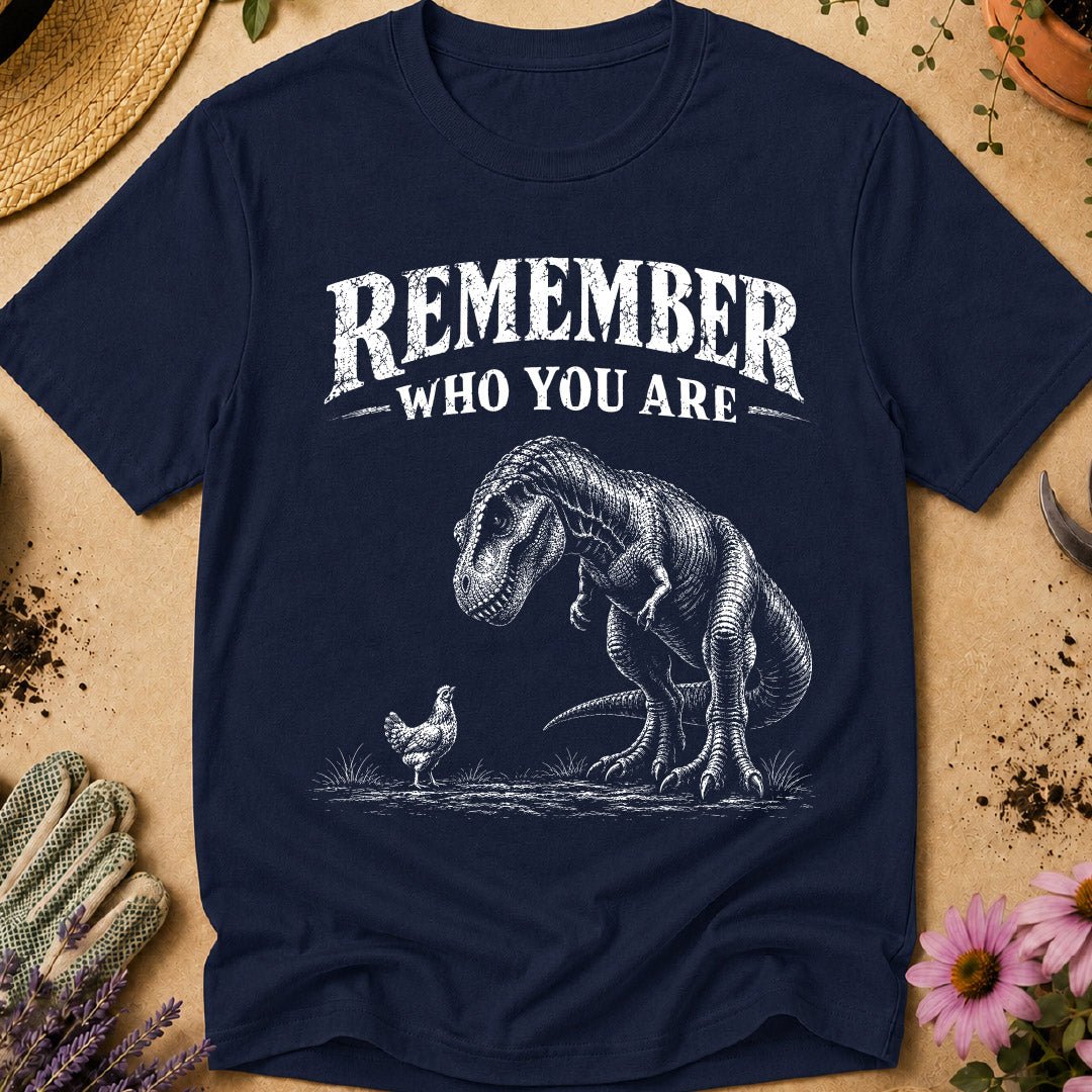 Funny chicken keeper shirt featuring a T. rex looking down at a chicken with “Remember Who You Are,” a humorous dinosaur chicken T-shirt for backyard chicken keepers and chicken lovers.