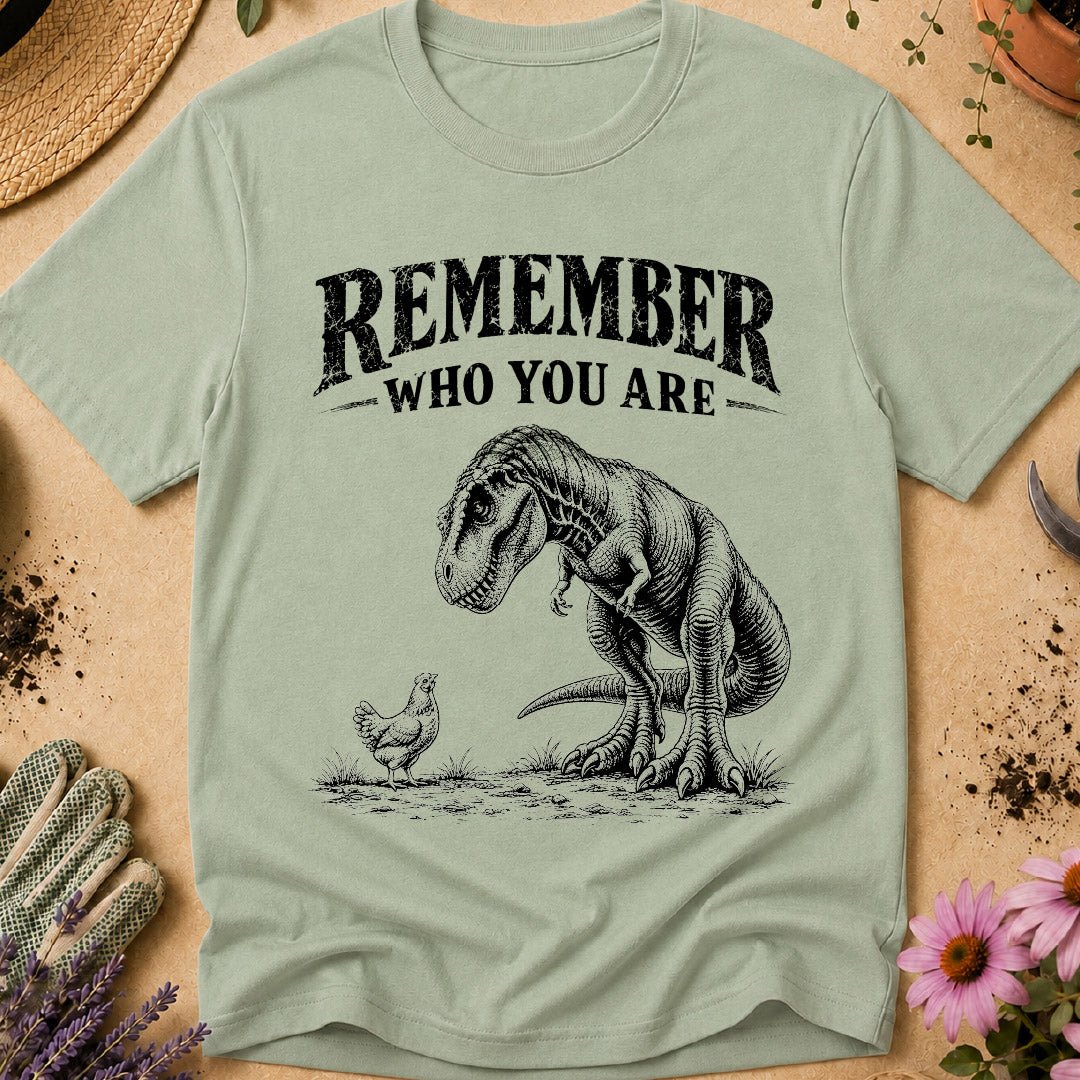Funny chicken keeper shirt featuring a T. rex looking down at a chicken with “Remember Who You Are,” a humorous dinosaur chicken T-shirt for backyard chicken keepers and chicken lovers.